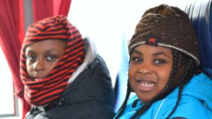 Akbene Abedi-Larteys dotter och son hoppas på att få åka och simma snart igen. Då kan man ta bussen, menar de. Två barn som åker buss, en flicka och en pojke.