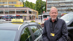 Hannu Polttila, som kör taxi, säger att många kunder varit oroade över hur de nu ska beställa taxi. Hannu Polttila står vid taxibil.