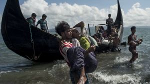 Kan blockkedjor i framtiden användas för att identifiera flyktingar? Arkivbild på en bangladeshisk man som hjälper flyende rohingyer att ta sig i land på bangladeshisk mark vid floden Naf den 30 september 2017.