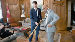 Kanadas premiärminister Justin Trudeau och Willie O'Ree i samspråk Justin Trudeau och Willy O'Ree beundrar en hockeyklubba.