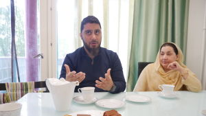 Omar tycker inte att allt har gått rätt till i processen. Mamma och sonen sitter vid köksbordet. Mir Omar förklarar någonting och har händerna upplyfta framför sig.