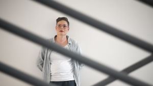 Kriminolog Maria Normann säger att kärlek över fängelsemurarna inte alltid är rosenskimrande. "Det kan handla om mycket annat än kärlek". En kvinna står framför en vit vägg. Hon ser åt vänster. Hon ser allvarlig ut. I framgrunden metallstänger.