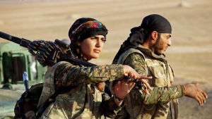 Kurdiska styrkor gjorde en avgörande insats i kampen mot terrorgruppen IS i Irak och Syrien. De kvinnliga kurdiska krigarna spred skräck bland IS-krigarna, som trodde att de inte kommer till himlen om de blir dödade av en kvinna. En kvinnlig och en manlig soldat på marsch iklädda kamouflagedräkter. Kvinnan bär ett tungt maskingevär över axeln.