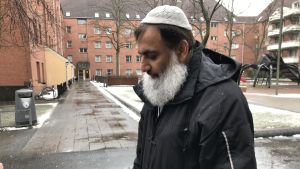 "Mjølnerparken är i en positiv utveckling, om vi får kan vi ändra utvecklingen på kort tid", säger Muhammed Aslam. En man med huvudbonad och stort grått skägg på en innergård.