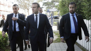 Emmanuel Macron, mitten, med Benalla, höger, på väg till vallokalen för att rösta i presidentvalets andra omgång 2017. Emmanuel Macron med Alexandre Benalla inför den andra omgången i det franska valet 2017.