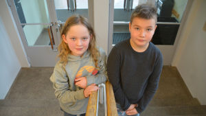 Vilde Hellsten och Jami Norrila tycker att de som bor i Liljendal, Pernå och Strömfors också räknas som Lovisabor. Två barn i en trappuppgång.
