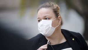 Familje- och omsorgsminister Krista Kiuru har fått mycket kritik under de senaste dagarna och riksdagen har röstat om hennes förtroende. Hon ställde inte upp på intervju på vägen in till förhandlingarna. Krista Kiuru iklädd i munskydd utanför Ständerhuset 15.10.2020