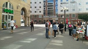 Nurminen tycker att livet på Stockholms gator är ganska vardagligt. Människor köar på ett torg för att köpa jordgubbar.