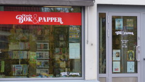 Nya fönstertejpningar på nya fönster och nya evenemangsplanscher på ny ytterdörr. Bokhandel och skyltfönster utifrån. Står Karis bok & papper.