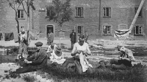 Fångar som reparerar sina kläder på gården. Fångar på Sveaborg 1918, syr kläder på gården