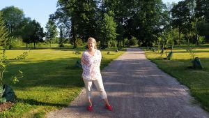 Nina Edgren Henrichson i den färska äppelallén i Kommendantsparken. Kvinna står i allé av små äppelträd.