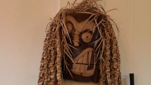 Maskerna ska skrämma bort onda andar som annars kan skada mah meri-folket. Maskerna används under alla viktiga animistiska ritualer. Bild på skulptur i trä som föreställer ett förvridet ansikte.