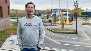 Rektor Janne Holmkvist tycker flytten har gått bra. En man i collegetröja står ute på en skolgård.
