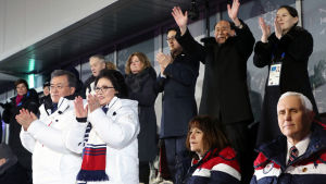 Vicepresident Mike Pence med sin fru Karen sitter på bänkraden framför Kim Yo-Jong och Kim Yong-Nam. Det sydkoreanska presidentparet står och klappar klädda i vita rockar Vicepresident Mike Pence med sin fru Karen sitter på bänkraden framför Kim Yo-Jong och Kim Yong-Nam. Det sydkoreanska presidentparet står och klappar klädda i vita rockar