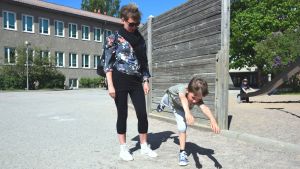 Milos Christides visar för mamma Åsa Olin och redaktören hur man gör delfinhopp. Mamma Åsa Olin med sonen Milos Christides ute på Seminariskolans gård i Ekenäs en sommardag. Milos visar hur man gör ett delfinhopp.