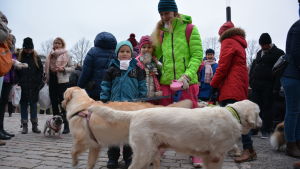 Noel, Erin och mamma Liselotte uppskattade evenemanget. Två golden retriever-hundar tillsammans med sin matte och familjens två barn iklädda varma kläder utanför Mikealskyrkan.