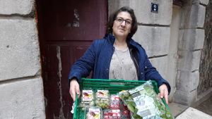 Khadija Zoukou på välgörenhetsorganisationen La Main de l’Autre "Din nästas hand" bär ut en låda full av mat till skåpbilen. Khadija Zoukou på välgörenhetsorganisationen La Main de l’Autre "Din nästas hand" bär ut en låda full av mat.