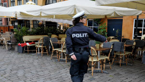 Ibland har polisen kallats in, som här för att kontrollera avstånden i restaurangkvarteren kring Nyhavn. Kvinnlig polis övervakar avståndet mellan restaurangstolar i Nyhavn