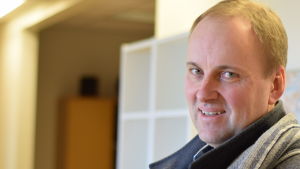 Tom Simola, vd och chefredaktör för ÅU säger att bevakningen kommer att bibehållas. Tom Simola som håller i en pappers kasse