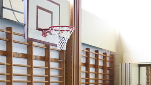 De praktiska ämnena såsom gymnastik är utmanande att undervisa i på distans. Bild på en tom gymnastiksal med ribbstolar och basketkorg