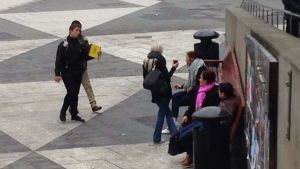 Sergels torg blir en plats att vara på för dem som saknar hem. Några personer sitter på en bänk på Sergels torg.