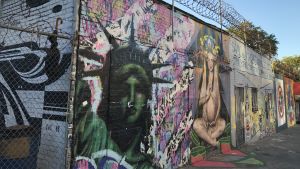 Somliga blir obekväma när de ser graffiti, som den här i Astoria, Queens. Frihetsgudinnan som graffitikonst på mur med taggtråd i Queens.