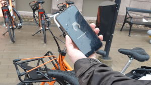 Applikationen i telefonen låser upp cykeln efter en stund. En smarttelefon med en applikation så man kan hyra stadscykel.