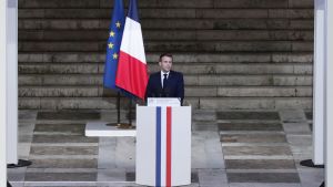 Macron: ''Paty mördades av ynkryggar'' Bild på frankrikes president framför en kista.