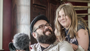 Stefan Svanfeldt tillsammans med sin dotter Freja. Stefan håller i filmutrustning och ler mot sin dotter Freja.