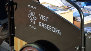 Det står "Visit Raseborg" på lådan. Visit Raseborg-logga syns på cykeln.
