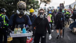 En demokratiaktivist kom bärande på brännflaskor vid universitetkampuset på Chinese University of Hong Kong, där studenterna drabbade samman med polisen. En person bär en bricka med brännflaskor i Hongkong.