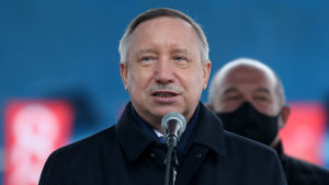 Aleksandr Beglov, S:t Petersburgs guvernör. En medelåldersman står och pratar i en mikrofon. Bakom honom ses en annan man med munskydd.