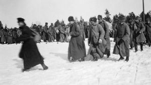 Flyktingar kommer till Björkö. Svartvit bild från mars 1921. Människor i vinterkläder går i snön. Flyktingar kommer till Björkö