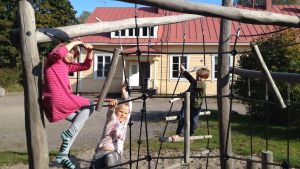 Emma Tolonen, Linnéa Lindh och Emil Rikberg är glada för att de får fortsätta i sin byskola Pernå kyrkoby skola. Barn klättrar i klätterställning på skolgården