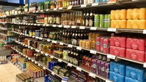 Hur mycket pengar sätter du på alkoholdrycker per år? Butikshylla med öl och alkoläsk.