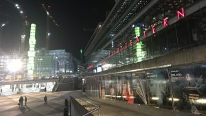 Fasaden av Kulturhuset stadsteatern speglar den gröna obelisken på Sergels torg.