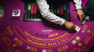 Veikkaus behandlar alla spelare lika och delar inte ut enskilda insatsbegränsningar. En croupier vid ett blackjackbord.