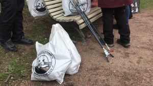 Alla fick varsin plastpåse att plocka skräp med och företaget Kuntec lånade ut skräpplockare åt deltagarna. några plastpåsar med skräp i och några skräpplockare står lutade mot en bänk