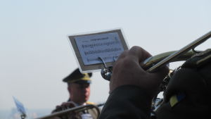 Ukrainas militär spelar Finlands nationalsång Vårt land. Ett blåsinstrument och noter. En soldatdirigent i bakgrunden.