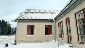 Vacuumrörsolfångarna på taket värmer vattnet i huset sommartid. Vacuumrörsolfångare på ett hustak.