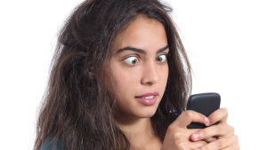 Får känslan av att någonting inte stämmer med exets nya tjej ... Kvinna med rufsigt hår och stirrig blick ser på telefon