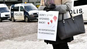 Demonstrant håller i en skylt med texten "Don't send afghans back"