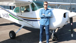 Piloten Mark Lindholm framför planet Cessna 172. Piloten Mark Lindholm framför ett flygplan.