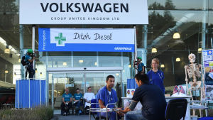 På söndagen demonstrerade Greenpeace-aktivister genom att blockera ingången till Volkswagens fabrik i Milton Keynes, England. De 800 anställda som inte släpptes in på sitt jobb erbjöds istället gratis hälsokontroller mot avgasrelaterade sjukdomar. Greenpeace-demonstration på Volkswagens fabrik i Milton Keynes, England, augusti 2018.