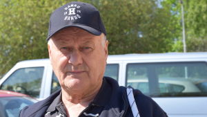Kepsen på Jouko Kavander fungerar delvis som en adresslapp. Också hjärtat klappar för Hangö. En man med keps som det står Hangö-Hanko på ser in i kameran. Utomhus