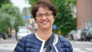 Gunilla Träskelin är ändå hoppfull inför framtiden. Kvinna står på en gata och ler.