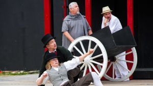 Phileas Fogg (Markus Haakana), Jean Passepartout (Emma Nordblad) och i bakgrunden Elefanten (Tommy Haakana) och Elefantförsäljaren (Dan Idman). Phileas Fogg och Jean Passepartout på scen