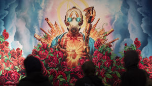 Borderlands 3 finns än så länge inte för Stadia, men Google har lovat att spelet dyker upp på speltjänsten innan 2020. Människor går förbi en stor reklam för Bordelands spelet. På reklamen ses en person omringad av vackra röda rosor och vapen. Han har på sig en mask där ögonen lyser blåa.