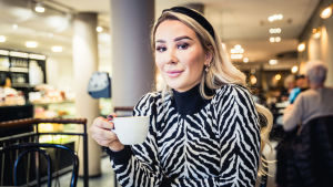 Alexandra känner sig idag hemma både i sig själv och i sitt jobb. Hon har besökt Finland flera gånger, både som inbjuden bloggerska på evenemang, men familjen hade också länge en sommarstuga ute i skärgården. Hon blev överraskad av att höra att också finländare känner till henne. Alexandra sitter på ett kafé och håller en kopp kaffe i sin vänstra hand. Hon ser rakt in i kameran och småler.