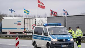 Tysk polisbil vid dansk-tyska gränsen, nodiska flaggor i bakgrunden.